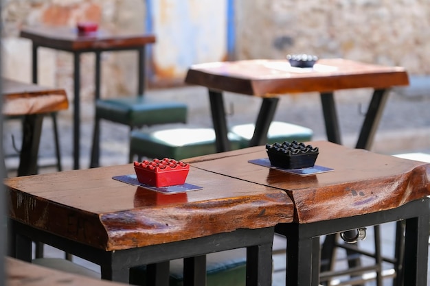 Cinzeiros em uma mesa de madeira em uma varanda aberta vazia de bar