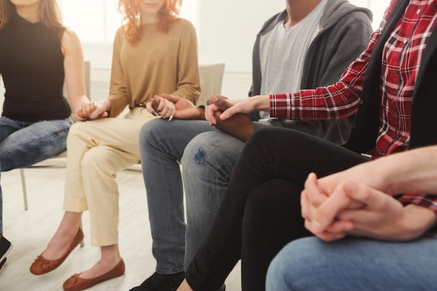 Círculo de confianza. Compañía de personas sentadas juntas y cogidas de la mano. Reunión de grupo de apoyo