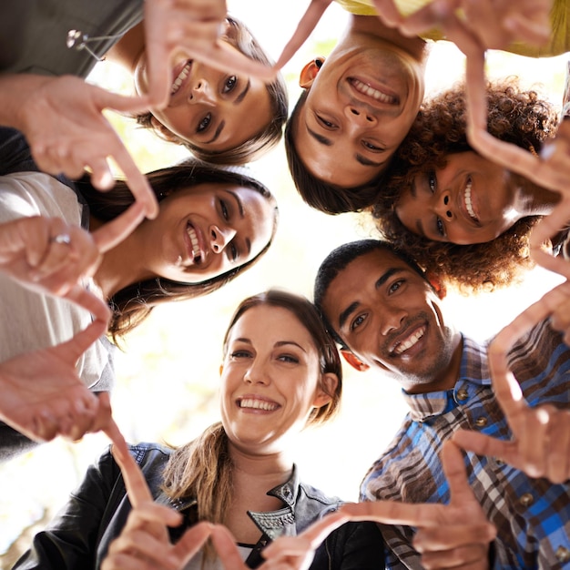 Círculo de estrela de dedo e retrato de amigos com unidade de diversidade e colaboração com um sorriso de trabalho em equipe de baixo ângulo e grupo de pessoas multirraciais reunidas para solidariedade e comunidade