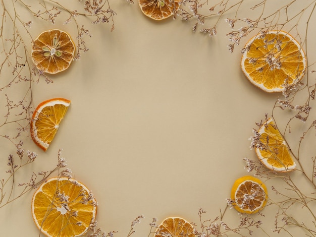 Círculo de flores secas e rodelas de laranja.