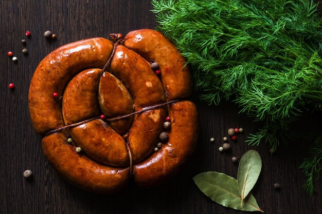 Círculo de salsicha frita caseira com especiarias em um fundo escuro de madeira Comida de carne