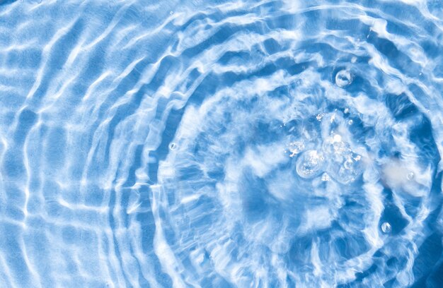 Círculo de fondo de la superficie del agua reflejos del sol en el agua de la piscina desde arriba