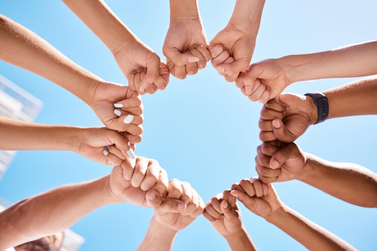 Foto el círculo de las manos del puño y la comunidad apoyan la diversidad, las personas protestan en grupo y luchan por la libertad en el fondo del cielo azul debajo del trabajo en equipo solidario y la motivación por la justicia, el objetivo, la confianza y el poder de la sociedad