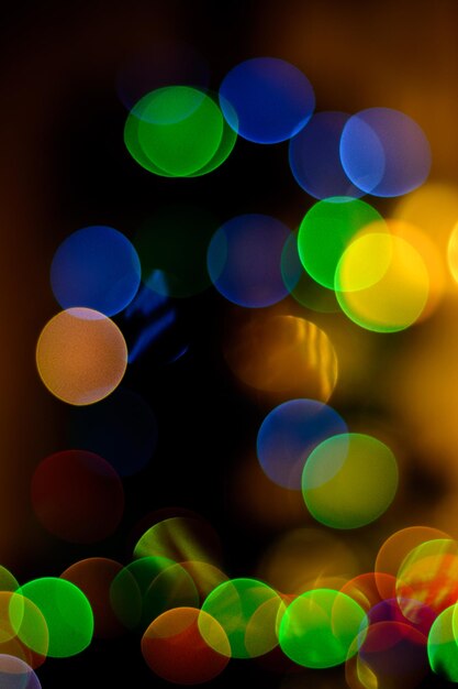 Círculos borrados do bokeh em cores festivas e frias de cipreste amarelo verde e azul