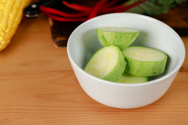 Círculos picados de calabacín en mesa de madera