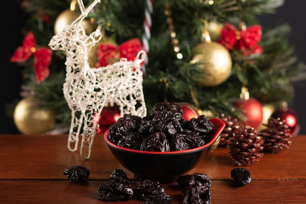 Ciruela en un recipiente sobre un fondo de Navidad