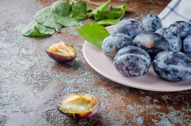 Ciruelas frescas en plato cerámico.