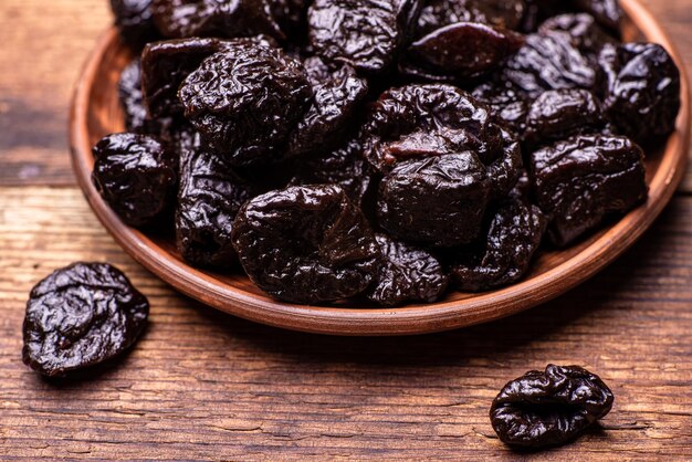 Ciruelas secas sobre un fondo de madera Frutos secos