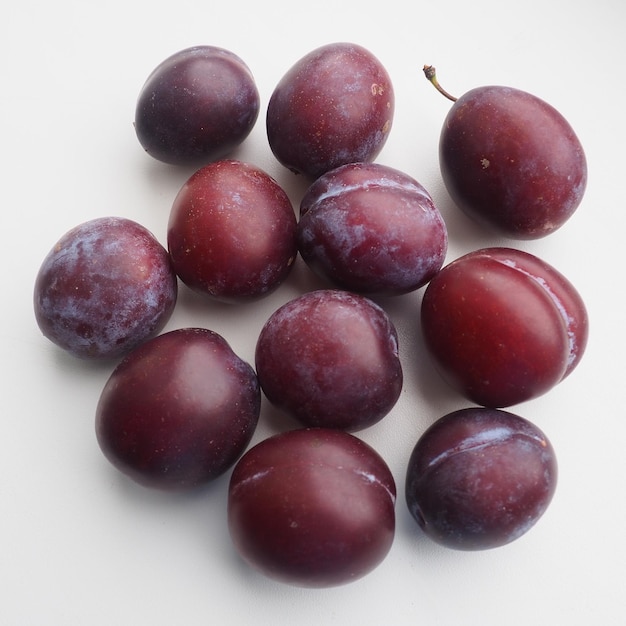 Ciruelas sobre un fondo blanco Jugosas frutas maduras