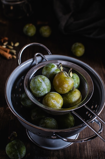 Foto ciruelas verdes en colador gris