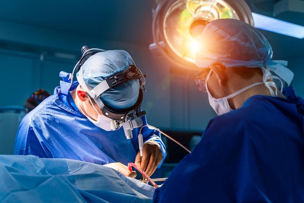 En cirugía Equipo médico que realiza la operación en el quirófano del hospital Trabajando con instrumentos quirúrgicos