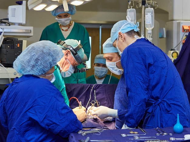 Un cirujano con asistentes realiza una operación en un hospital moderno. Equipo médico que realiza la operación.