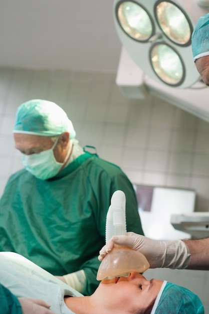 Cirujano colocando una máscara en la cara de un paciente