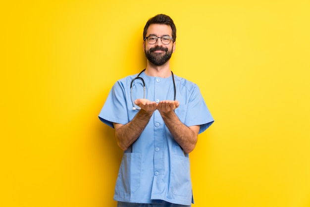Cirujano doctor hombre sosteniendo copyspace imaginario en la palma para insertar un anuncio