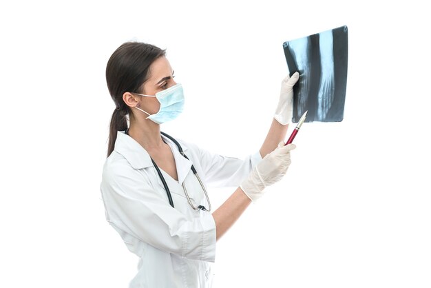 Cirujano examinando la radiografía del paciente en blanco