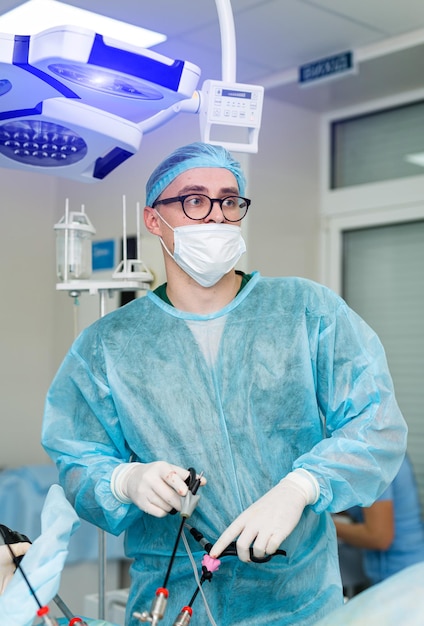 Cirujano hombre con guantes elásticos y máscara protectora Especialista en cirugía profesional con uniforme y máscara