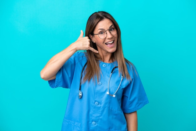 Cirujano de mediana edad mujer aislada sobre fondo azul haciendo gesto de teléfono Llámame de nuevo signo