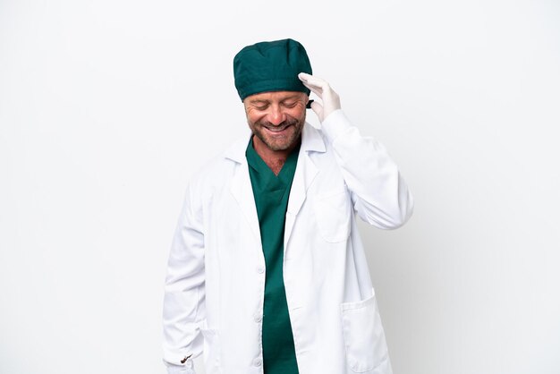 Cirujano de mediana edad en uniforme verde aislado sobre fondo blanco riendo