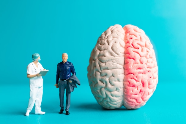 Cirujano de personas en miniatura habló con el paciente sobre las lesiones cerebrales. Concepto del Día Mundial del Accidente Cerebrovascular.