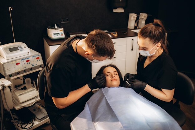 Cirujano plástico haciendo inyecciones faciales en la clínica