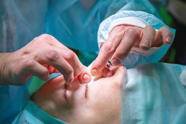 Cirujano y su asistente realizando cirugía estética en la nariz en el quirófano del hospital Rinoplastia de aumento de remodelación de la nariz