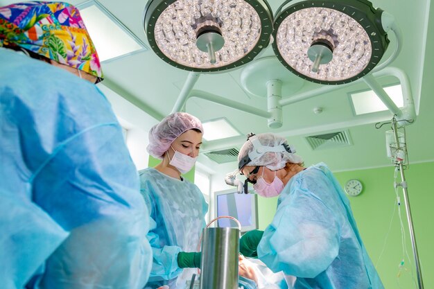 Cirujano y su asistente realizando cirugía estética en la nariz en el quirófano del hospital Rinoplastia de aumento de remodelación de la nariz