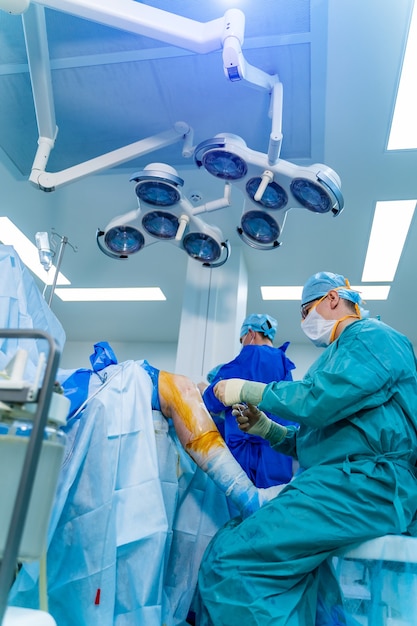 Cirujanos que realizan una operación quirúrgica en la sala de cirugía moderna y luminosa. Quirófano. Equipo moderno en clínica. Sala de emergencias.