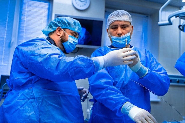 Cirujanos que trabajan en el quirófano Fondo del hospital Dos médicos masculinos en el trabajo