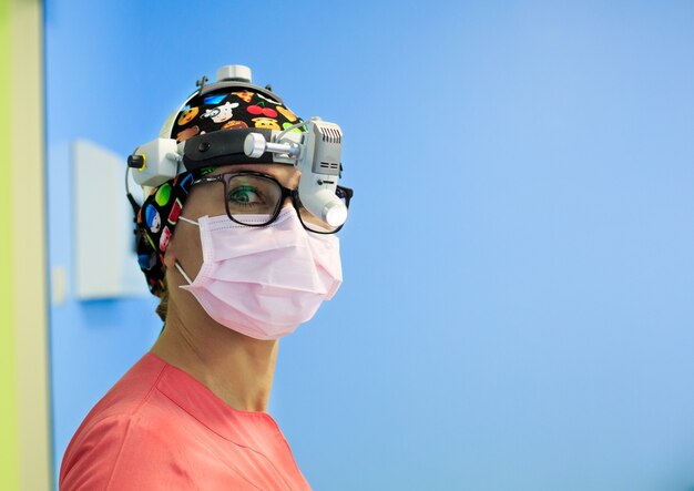 Cirurgiã com uma lupa na sala de operação