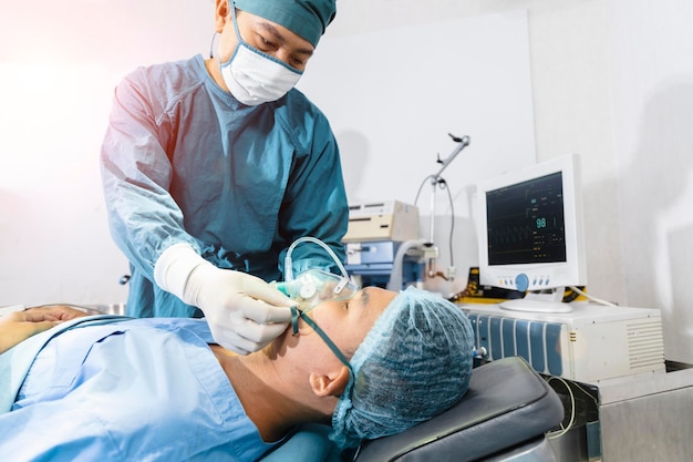 Cirurgião assistente colocou o paciente em uma máscara de oxigênio em preparação para a cirurgia