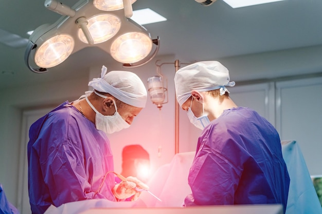 Cirurgião da equipe no trabalho na sala de cirurgia equipamento moderno na sala de cirurgia