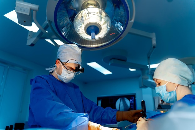 Cirurgião da equipe no trabalho na sala de cirurgia Equipamento moderno na sala de cirurgia