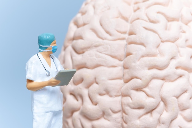 Cirurgião de pessoas em miniatura analisando o cérebro do paciente