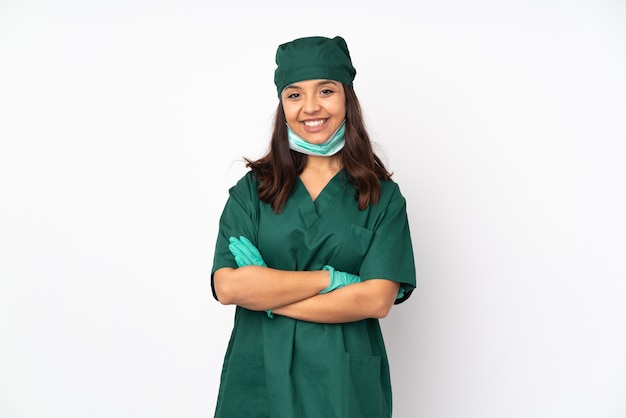 Cirurgião mulher de uniforme verde na parede branca, mantendo os braços cruzados