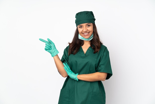 Cirurgião mulher de uniforme verde no dedo apontando branco para o lado