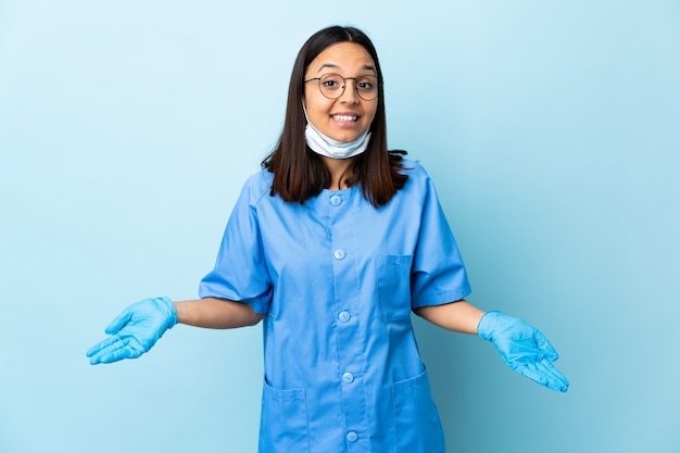 Cirurgião mulher sobre parede azul feliz e sorridente