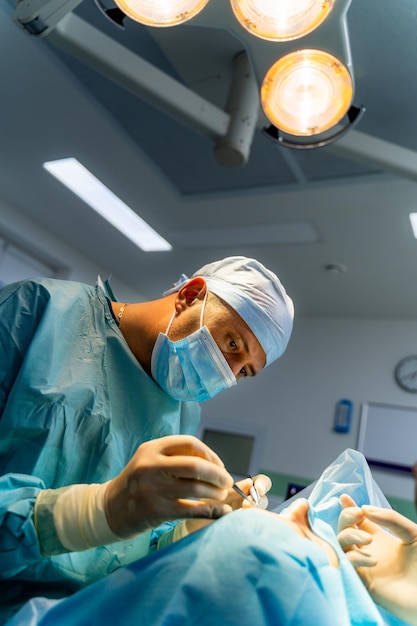 Cirurgião na sala de operação trabalhando com instrumentos cirúrgicos equipamentos modernos na sala de cirurgia