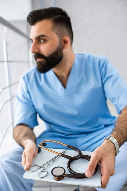 Foto cirurgião profissional com um tablet nas mãos consulta online e recepção de pacientes na internet