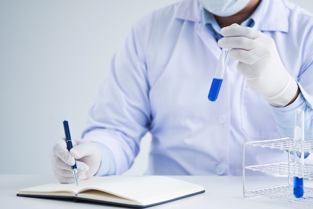 Foto cirurgião químico / cientista ensaio experimental teste tubo em laboratório