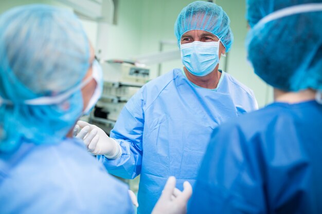 Cirurgiões interagindo entre si na sala de operação