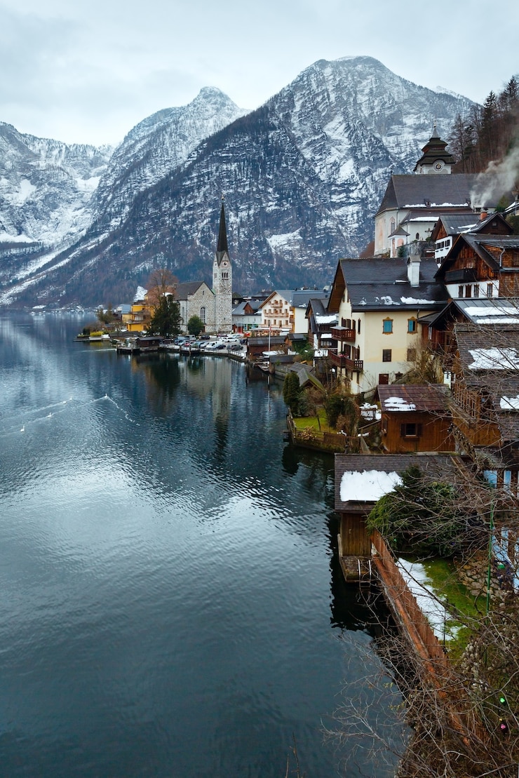 Foto cisnes no inverno alpine hallstatt town e vista do lago hallstatter see (áustria)