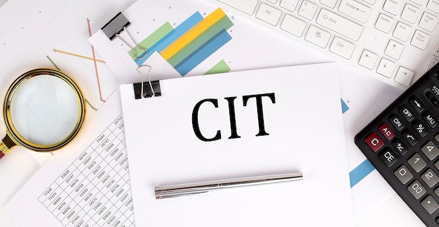 CIT-Text auf dem weißen Papier auf hellem Hintergrund mit Diagrammpapiertastatur und -rechner