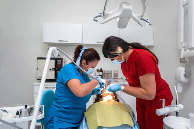 Cita con el dentista en una clínica dental colocando frenos en los dientes y tirando del arco para arreglarlo