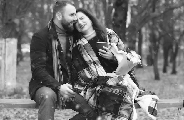 Cita en un parque amantes felices en un banco en clima nevado