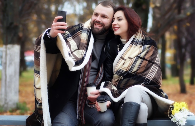 Cita en un parque amantes felices en un banco en otoño