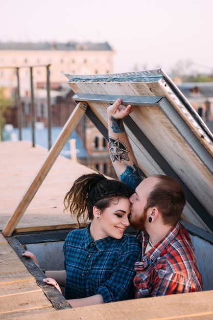 Cita romántica en la azotea. Primer plano de pareja de amor. Escena de película, relaciones amables. Gente sonriente feliz y joven en foco en primer plano, fondo urbano