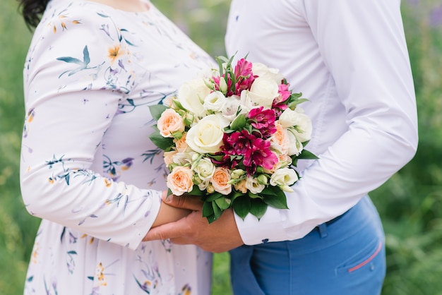 Una cita romántica de un chico y una chica, un primer plano de un ramo de flores, un regalo para una chica. La novia y el novio. Ramo de la boda