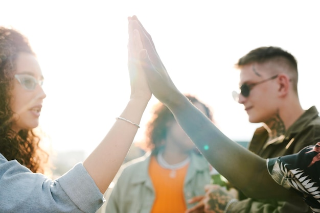 Foto citas interculturales jóvenes chocando los cinco contra sus amigos