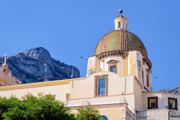 Citiscape mit der Kirche Santa Maria Assunta in der Stadt Positano an der Amalfiküste und am Tyrrhenischen Meer in Italien im Sommer. Blick auf die schöne mediterrane Kathedralenarchitektur in der Nähe von Sorrento.