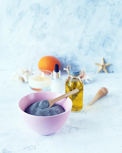 Cítricos de argila azul creme tinturas saudáveis de óleo aromático e conchas em um fundo leve